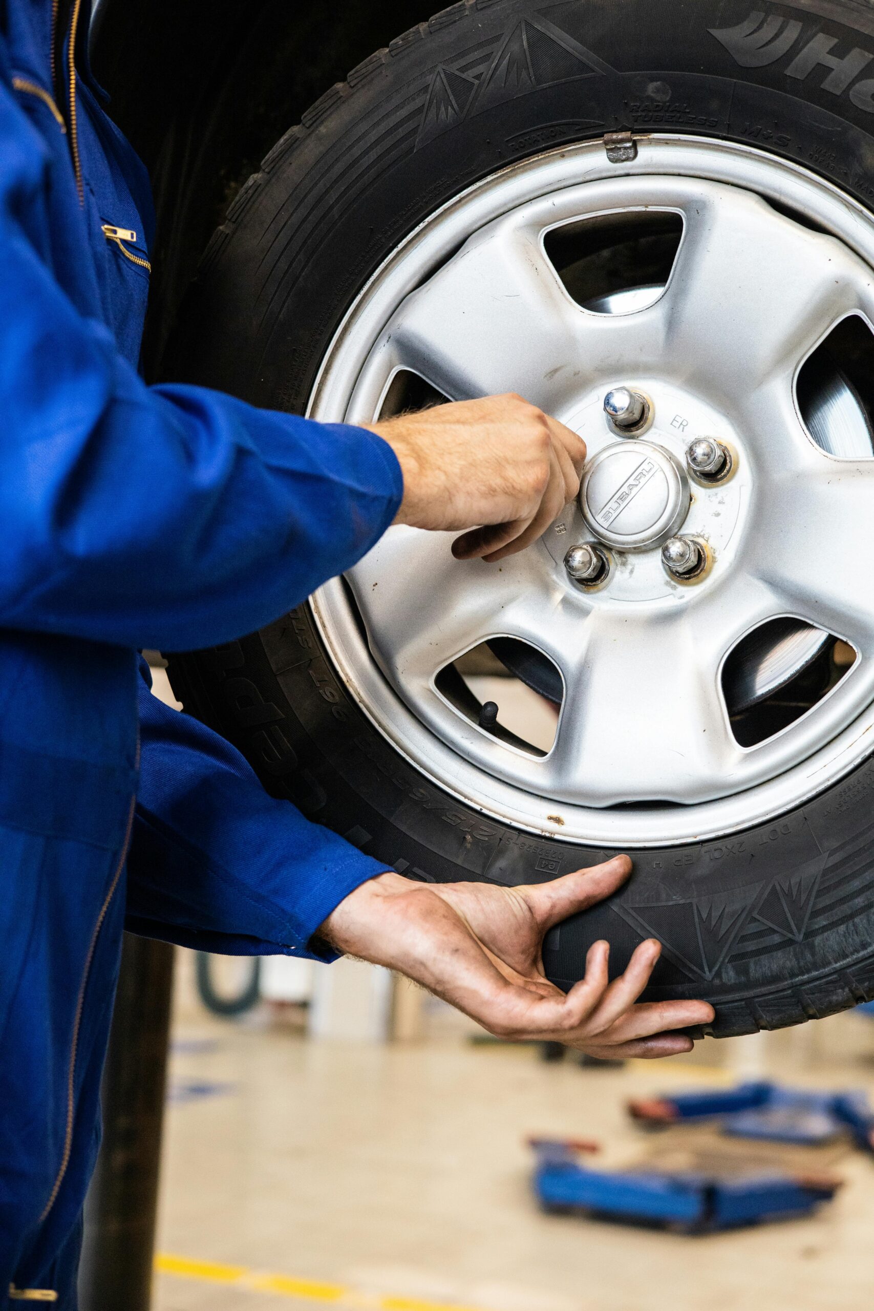 Photo by Artem Podrez: https://www.pexels.com/photo/a-person-in-blue-jumpsuit-holding-the-car-tire-8986175/